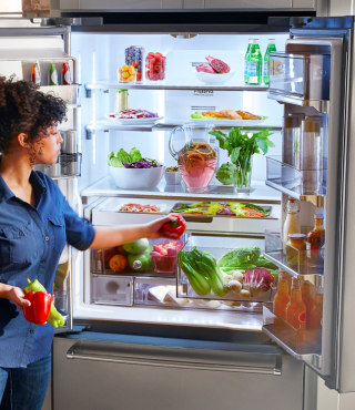 Person putting food in a refrigerator