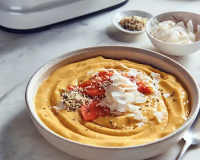 Tropical breakfast bowl topped with fruit and shaved coconut