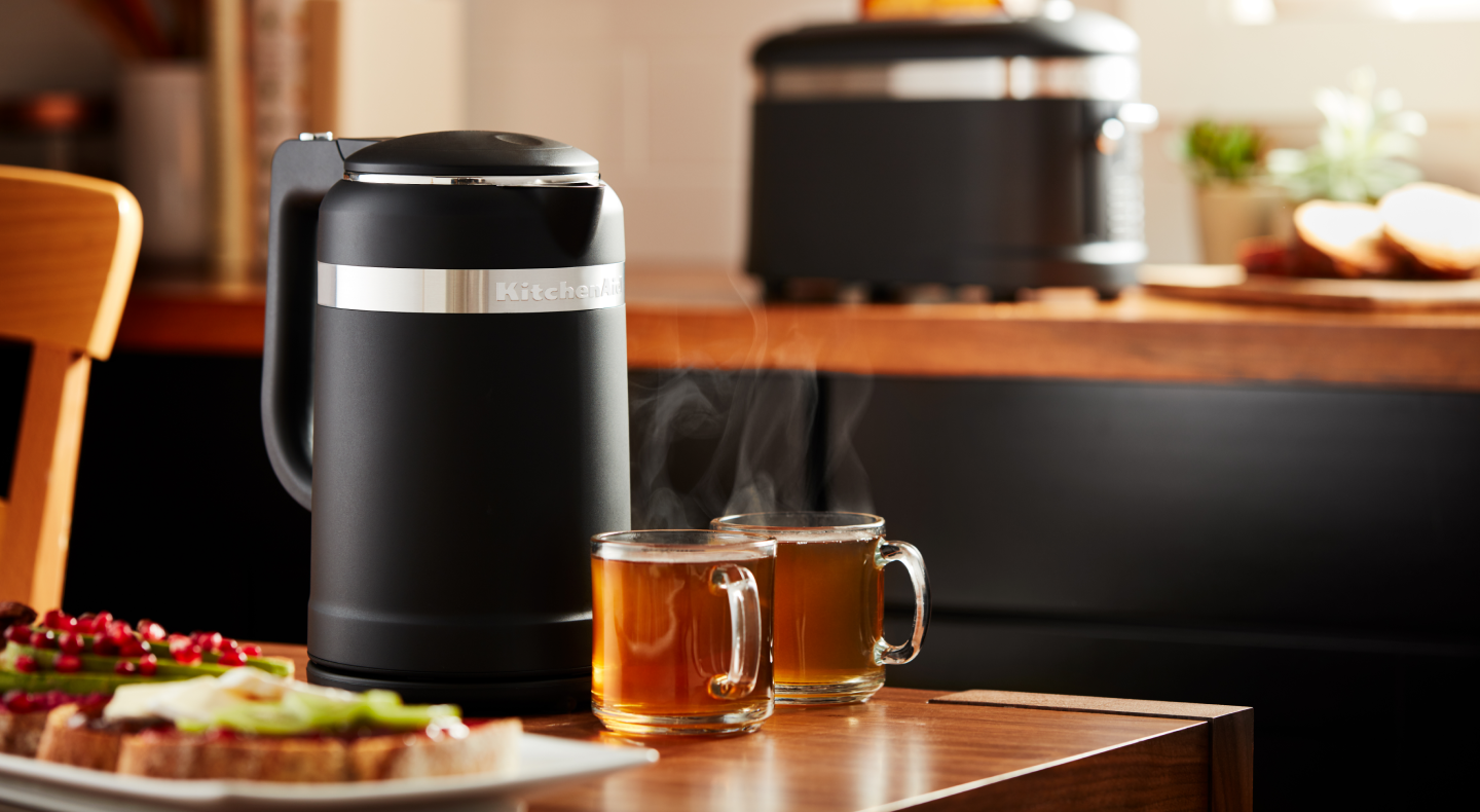 Black KitchenAid® electric kettle next to two cups of tea