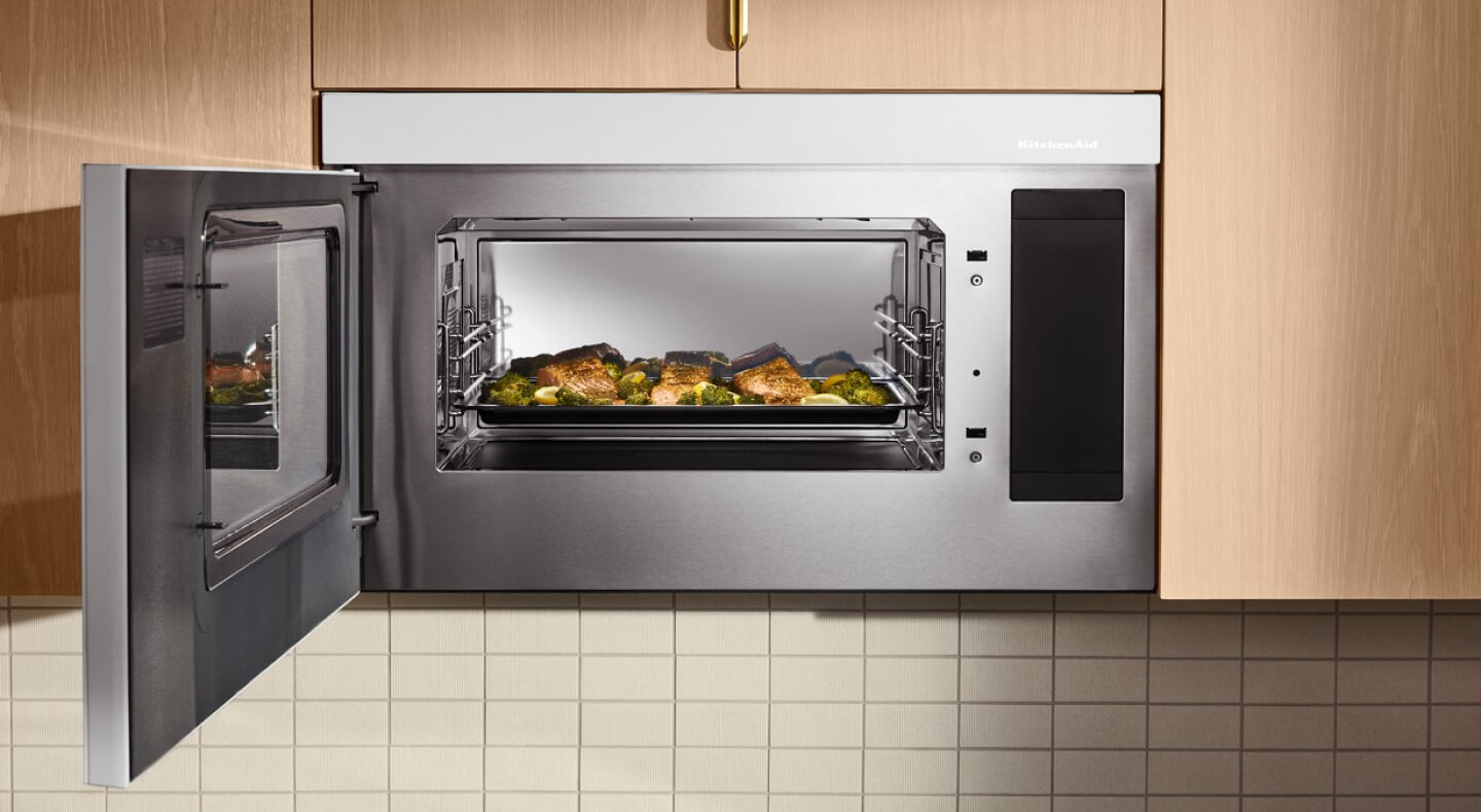 Fish and broccoli on tray inside a KitchenAid® microwave with the door open Fish and broccoli on tray inside a KitchenAid® microwave with the door open