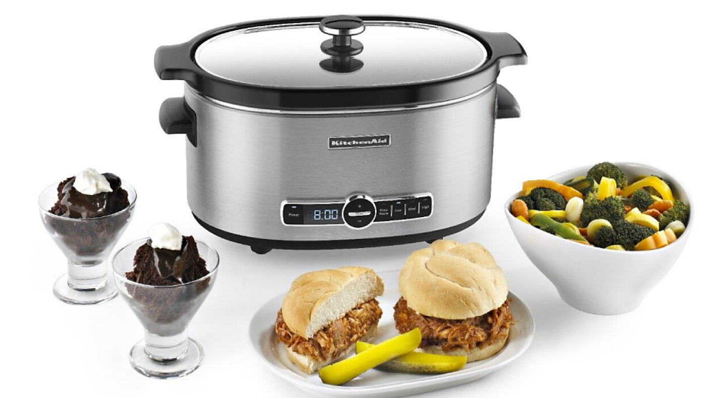 A KitchenAid® slow cooker surrounded by ice cream in a dish, pulled pork sandwiches and a bowl of veggies A KitchenAid® slow cooker surrounded by ice cream in a dish, pulled pork sandwiches and a bowl of veggies