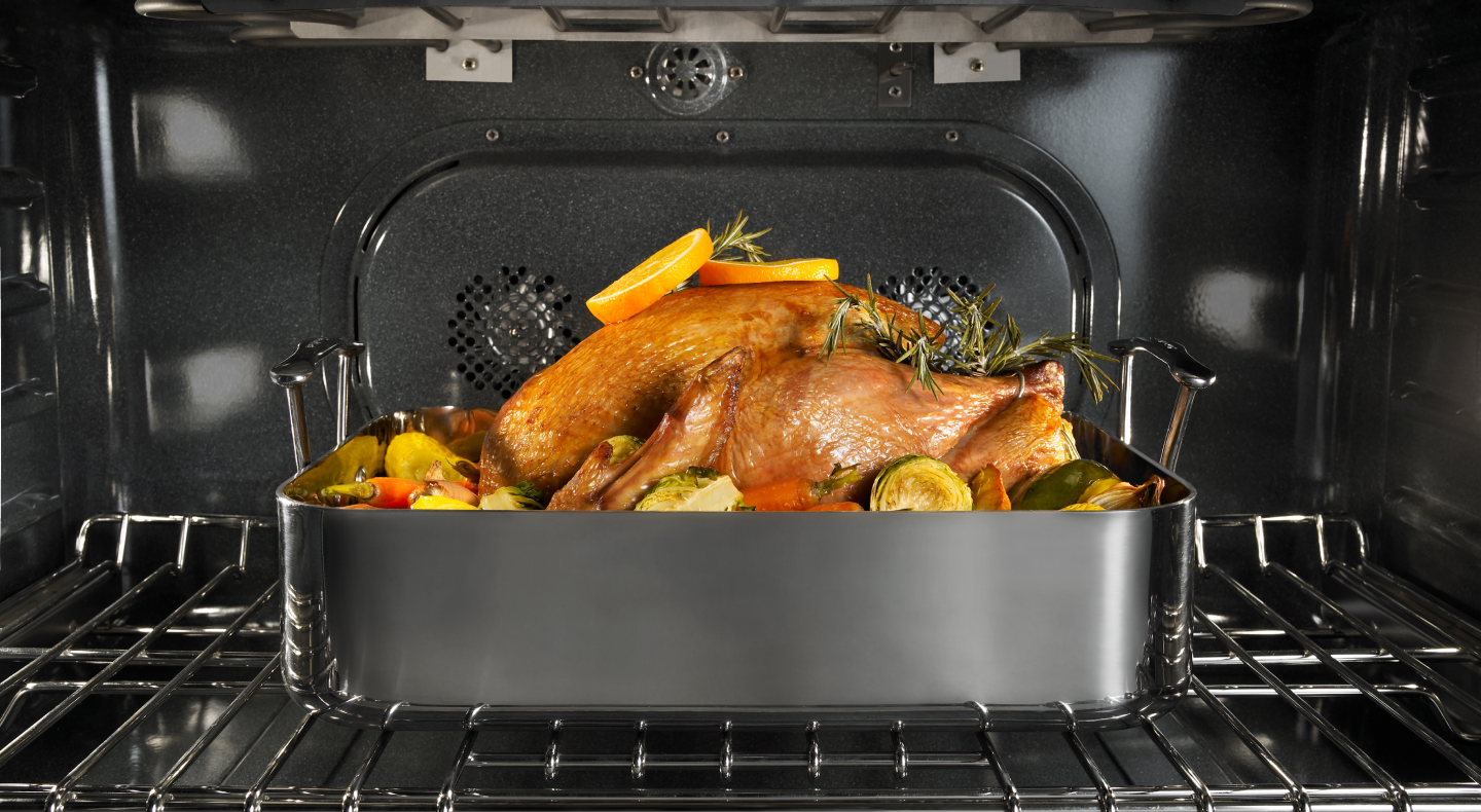 Chicken and vegetables roasting inside an oven Chicken and vegetables roasting inside an oven