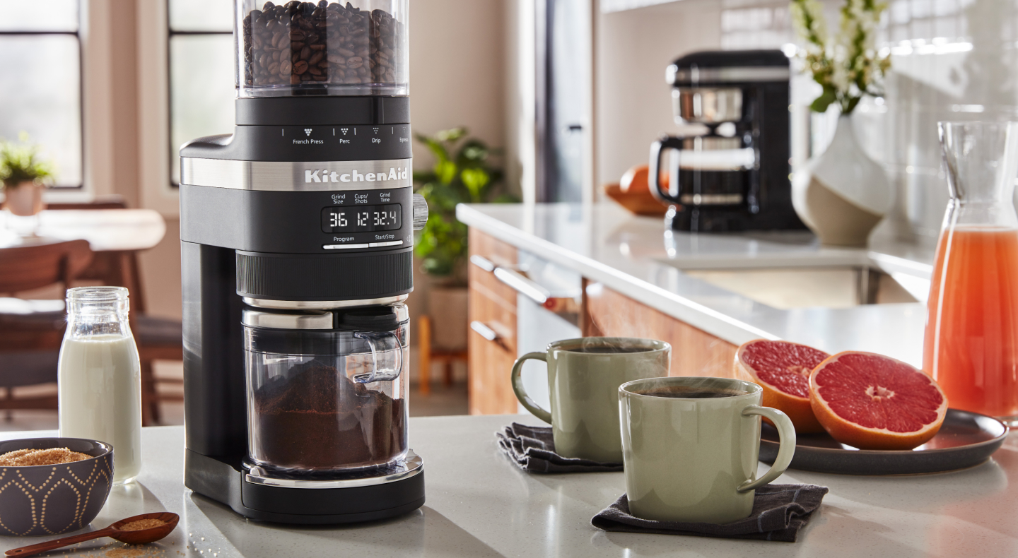 KitchenAid® burr grinder next to two coffee mugs KitchenAid® burr grinder next to two coffee mugs