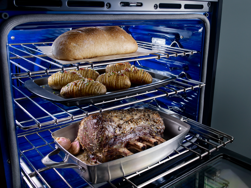A rack with trays of baked goods and a loaf of bread A rack with trays of baked goods and a loaf of bread