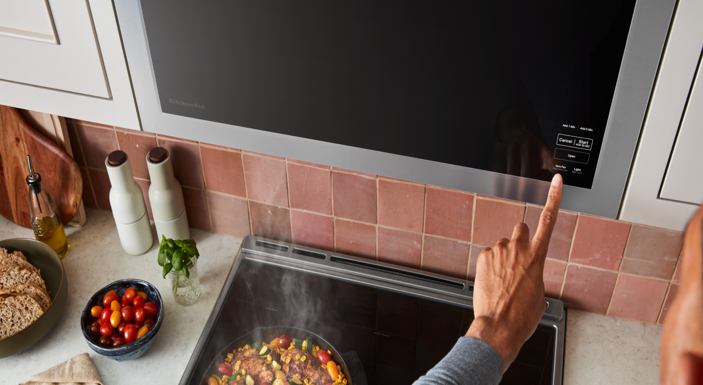 Hand making a selection on microwave