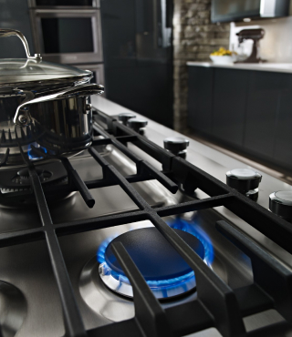 Blue flames simmering under a cooktop grate