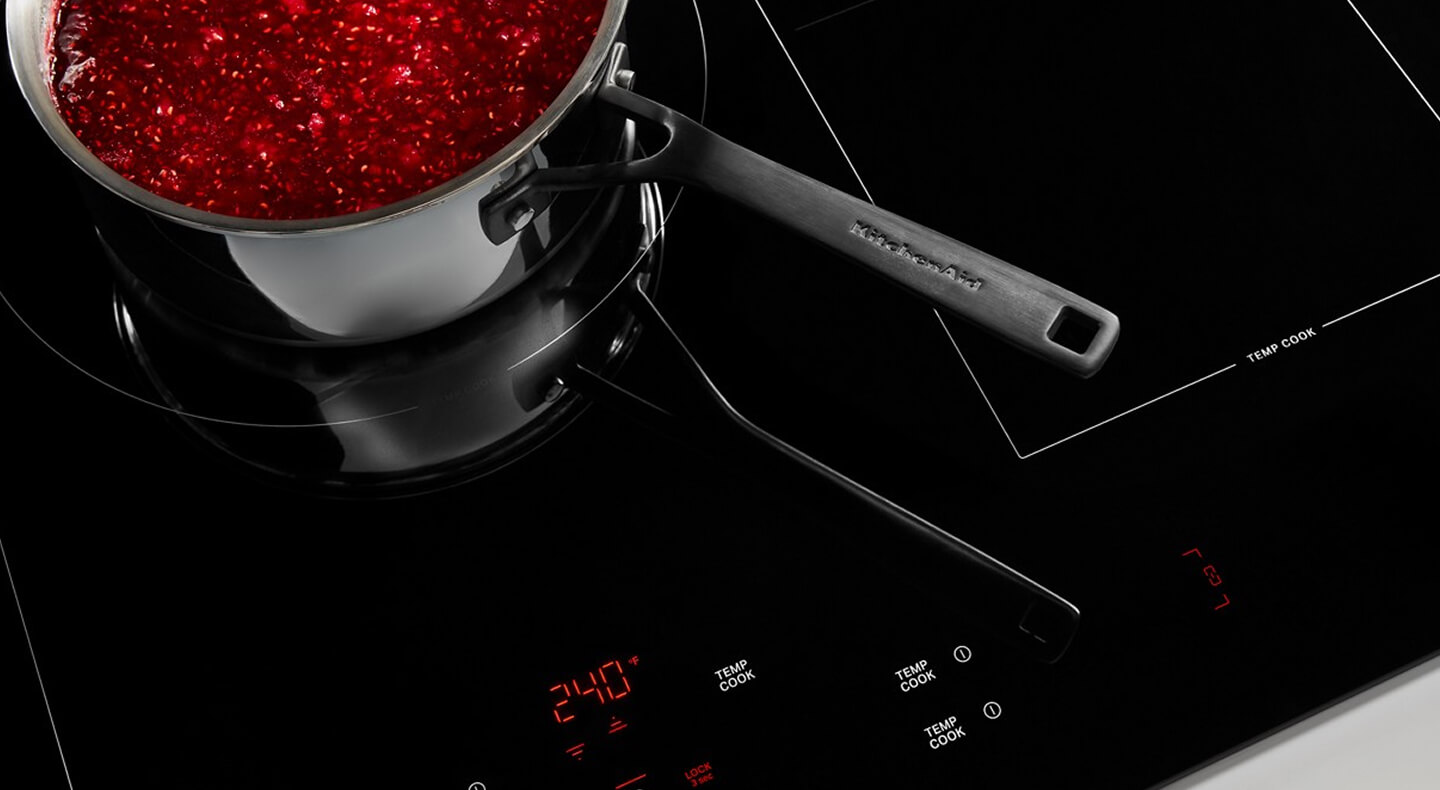 A KitchenAid® cooktop with a stainless steel pan on top