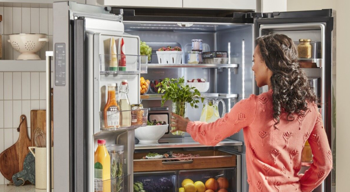 Person loading fresh herbs into a KitchenAid® French door refrigerator Person loading fresh herbs into a KitchenAid® French door refrigerator