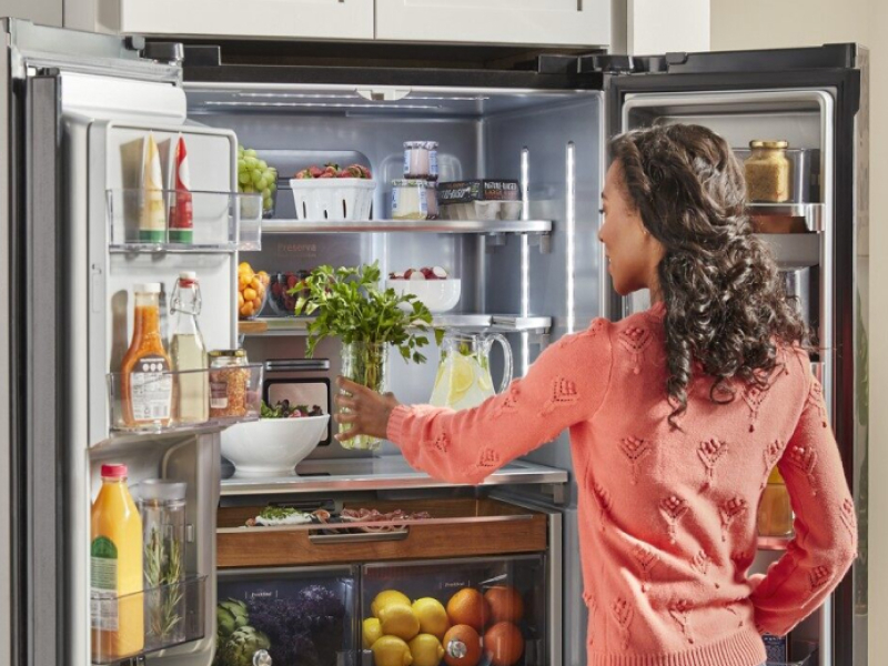 Person loading fresh herbs into a KitchenAid® French door refrigerator Person loading fresh herbs into a KitchenAid® French door refrigerator