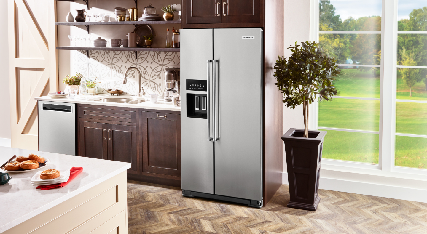 Kitchen sink surrounded by dishwasher and side-by-side refrigerator