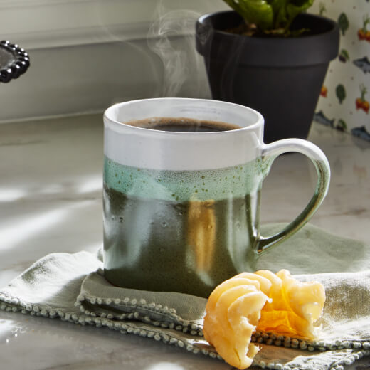 Black coffee and a half eaten donut Black coffee and a half eaten donut