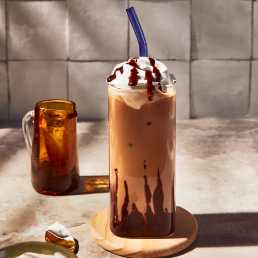 Iced mocha topped with whipped cream and chocolate drizzle