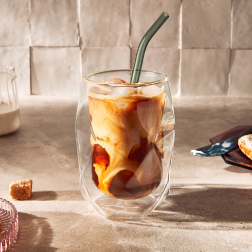 Iced coffee in a glass with a reusable straw Iced coffee in a glass with a reusable straw