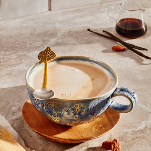 Latte in a ceramic mug with a stirring spoon Latte in a ceramic mug with a stirring spoon