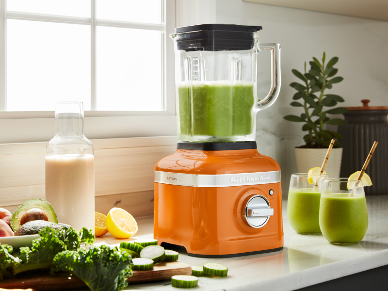 A KitchenAid® blender with freshly made juice on a modern kitchen counter.