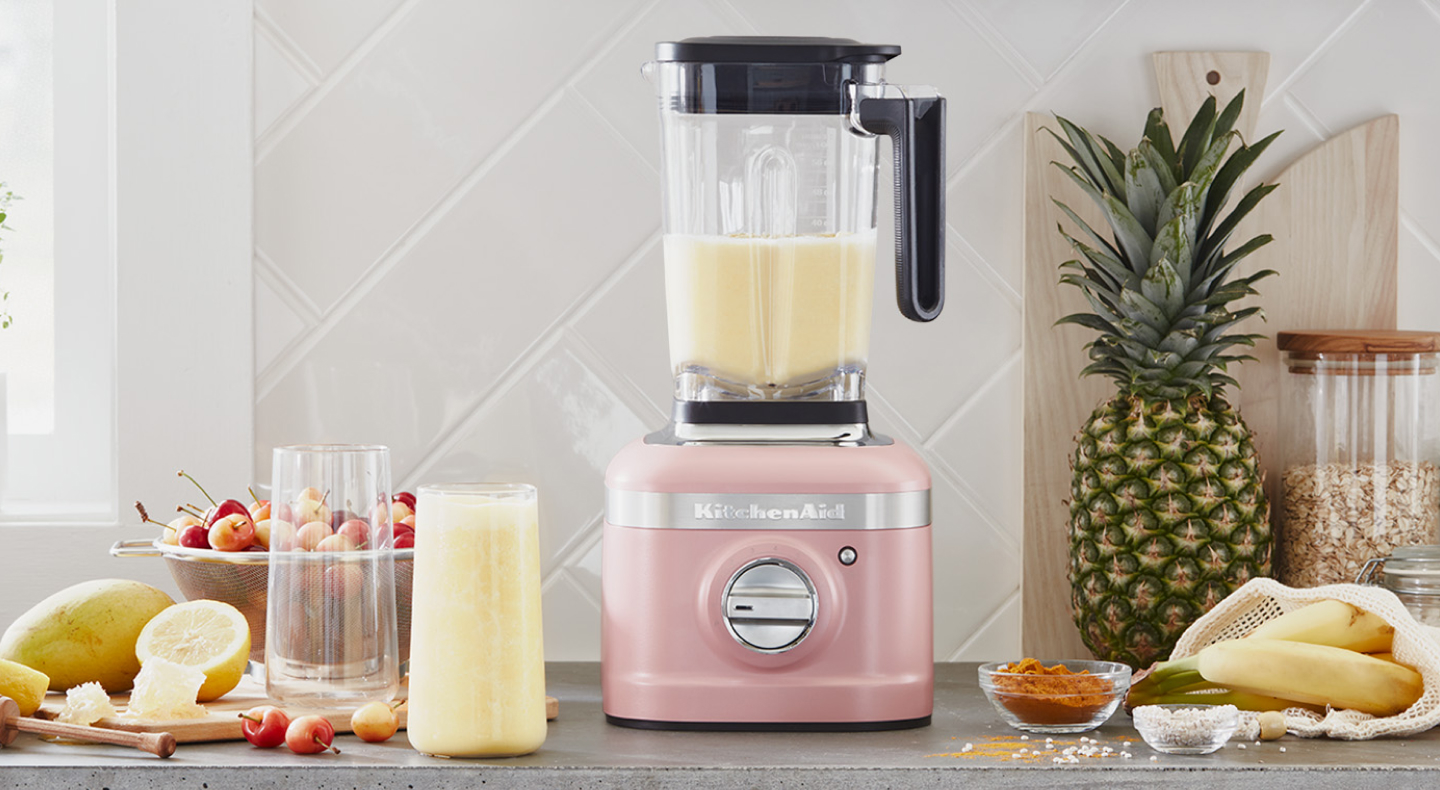 A KitchenAid® blender with a freshly made smoothie on a modern kitchen counter. A KitchenAid® blender with a freshly made smoothie on a modern kitchen counter.
