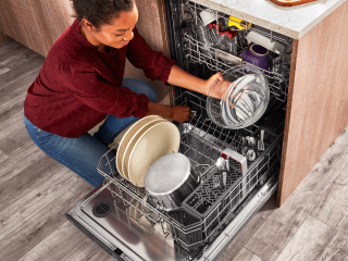 A person loading a dishwasher