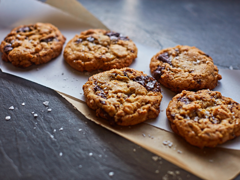 Freshly baked chocolate chip cookies on parchment paper