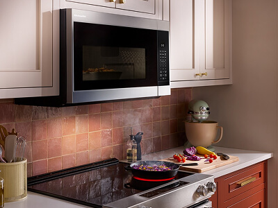 An over-the-range microwave built into cream upper cabinets