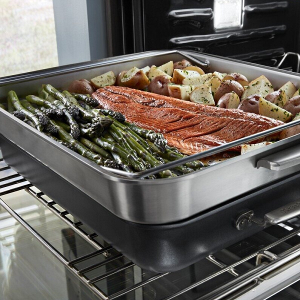 Salmon, potatoes and asparagus on a pan entering the oven