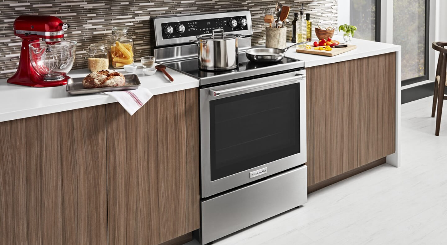 Freestanding KitchenAid® electric range with stainless steel cookware on top