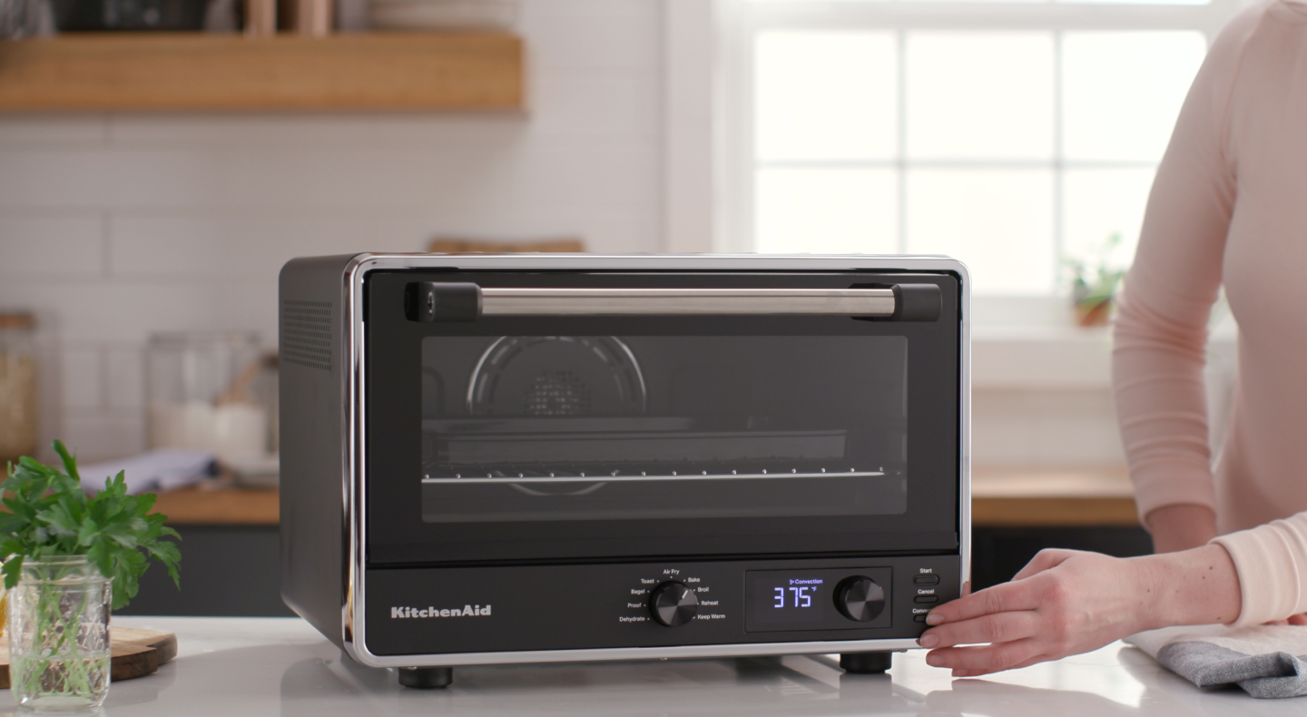 Person setting controls on a KitchenAid® countertop oven Person setting controls on a KitchenAid® countertop oven