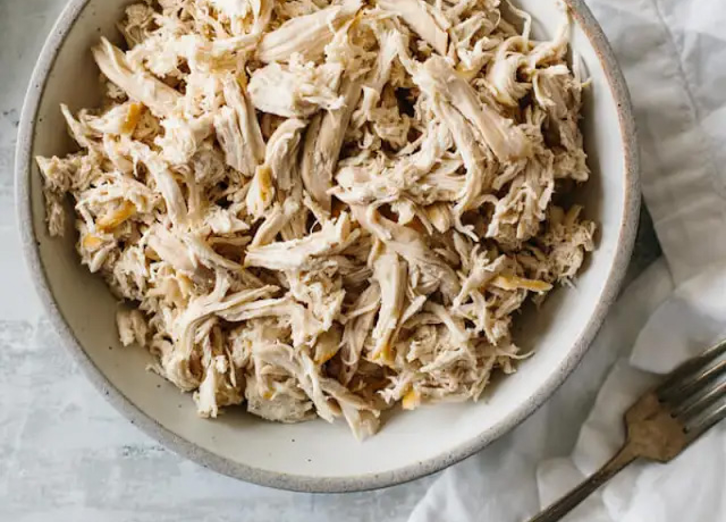 A bowl of shredded chicken. A bowl of shredded chicken.