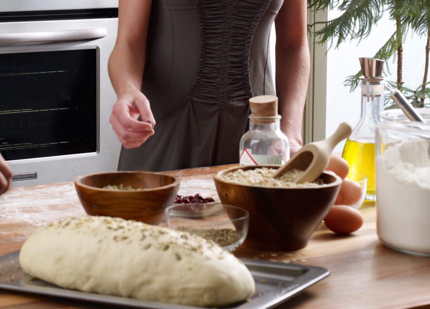 A woman adding spices to a loaf of bread dough that’s ready to go into the oven. A woman adding spices to a loaf of bread dough that’s ready to go into the oven.
