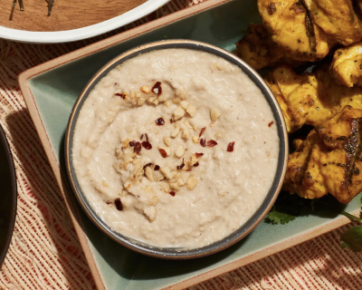 A bowl of peanut sauce with chopped nuts on top