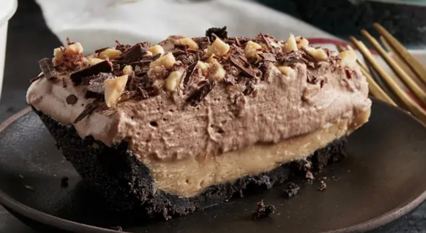 A homemade chocolate cake with nuts and chocolate shavings on top A homemade chocolate cake with nuts and chocolate shavings on top