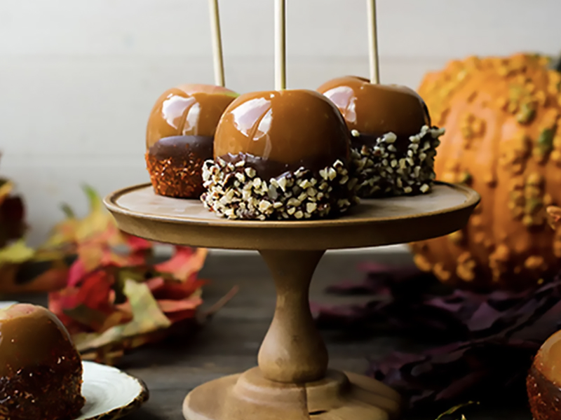 Caramel apples dipped in chocolate and chopped nuts Caramel apples dipped in chocolate and chopped nuts