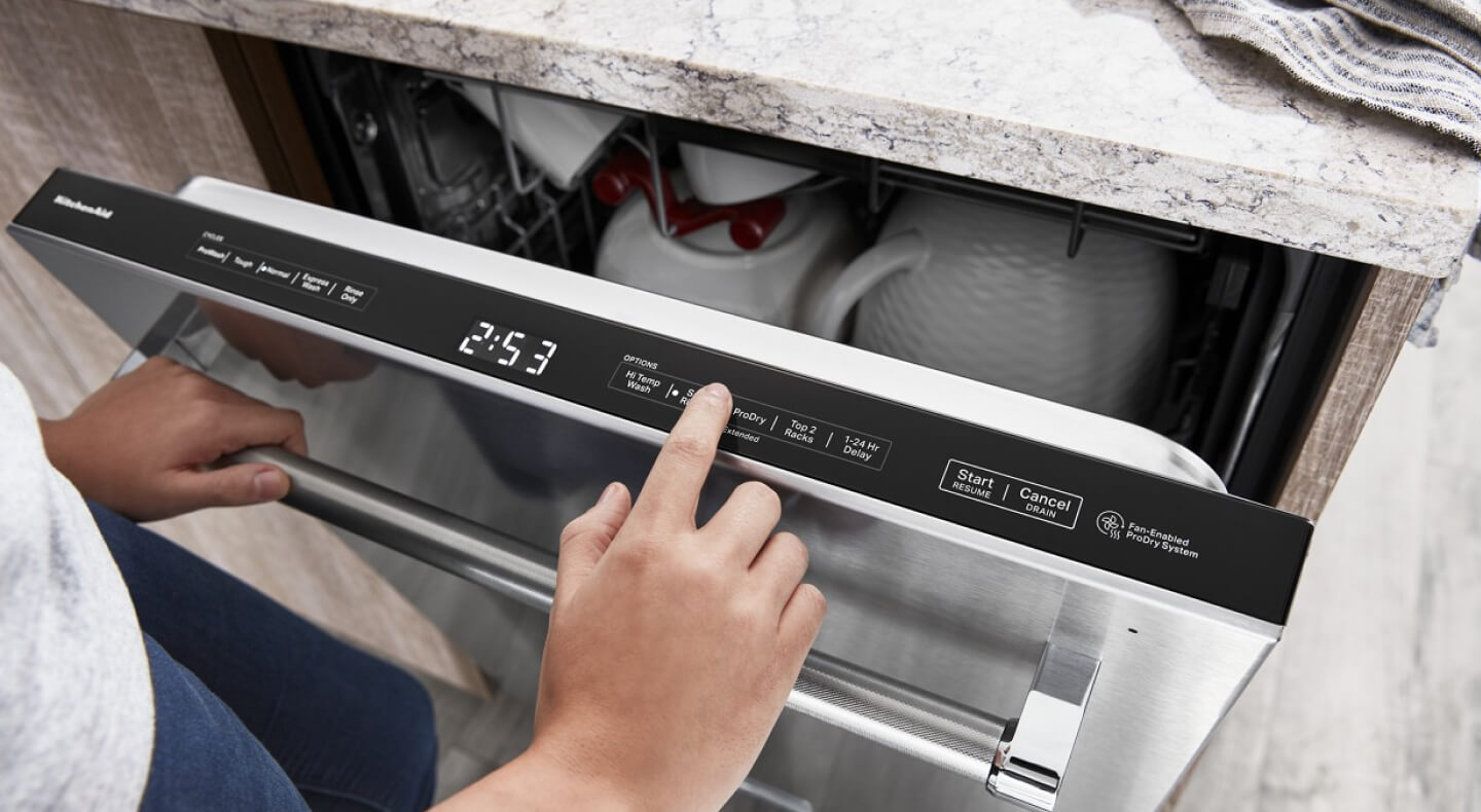 Person selecting a dishwasher cycle