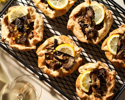 Savory mushroom galette topped with lemon wedges on wire cooling rack Savory mushroom galette topped with lemon wedges on wire cooling rack