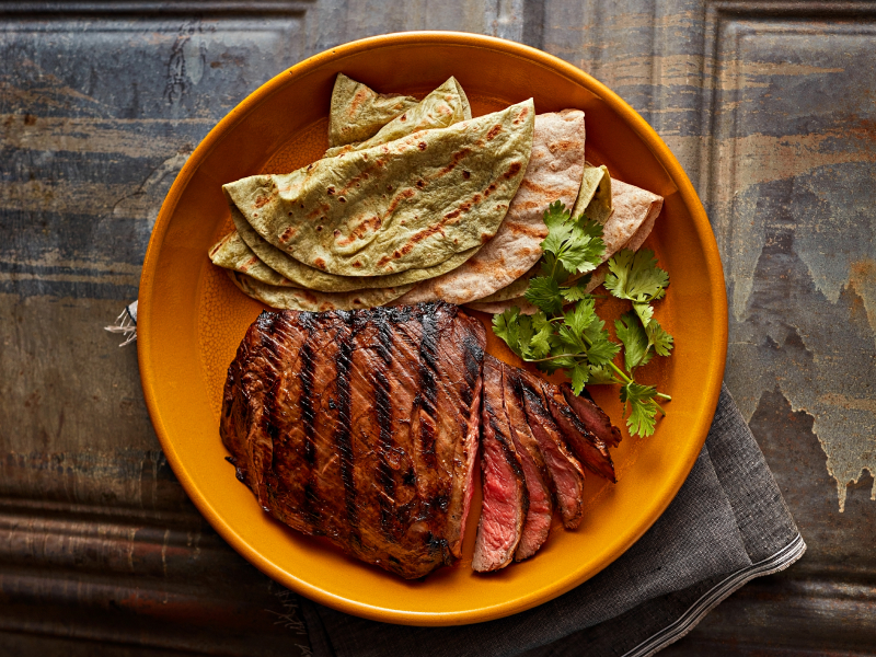 Sliced steak and fresh tortillas garnished with herbs Sliced steak and fresh tortillas garnished with herbs