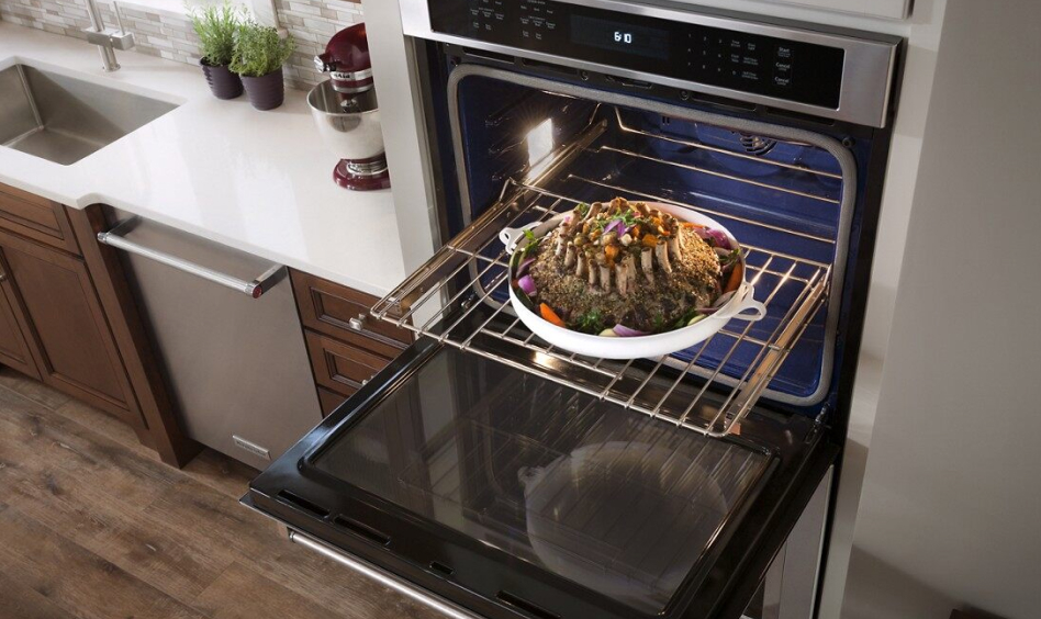 Rack of lamb being pulled out of an oven Rack of lamb being pulled out of an oven