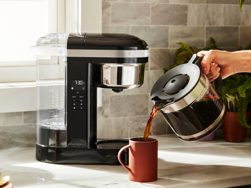 Person pouring a pitcher of coffee into a mug Person pouring a pitcher of coffee into a mug