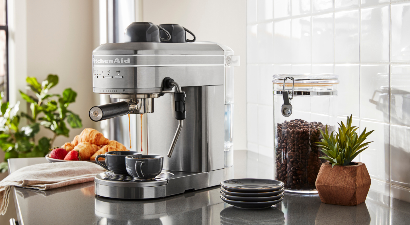 Silver KitchenAid® Semi-Automatic Espresso Machine on counter with coffee beans and croissants Silver KitchenAid® Semi-Automatic Espresso Machine on counter with coffee beans and croissants