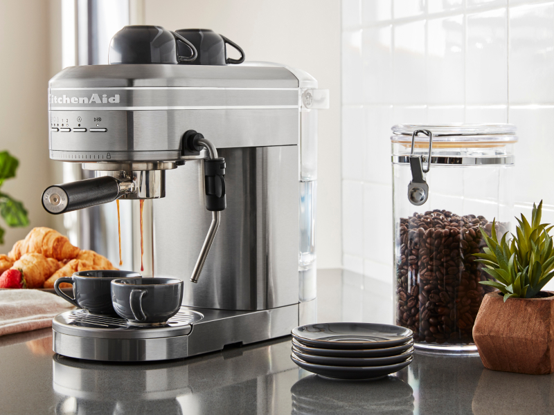Silver KitchenAid® Semi-Automatic Espresso Machine on counter with coffee beans and croissants Silver KitchenAid® Semi-Automatic Espresso Machine on counter with coffee beans and croissants