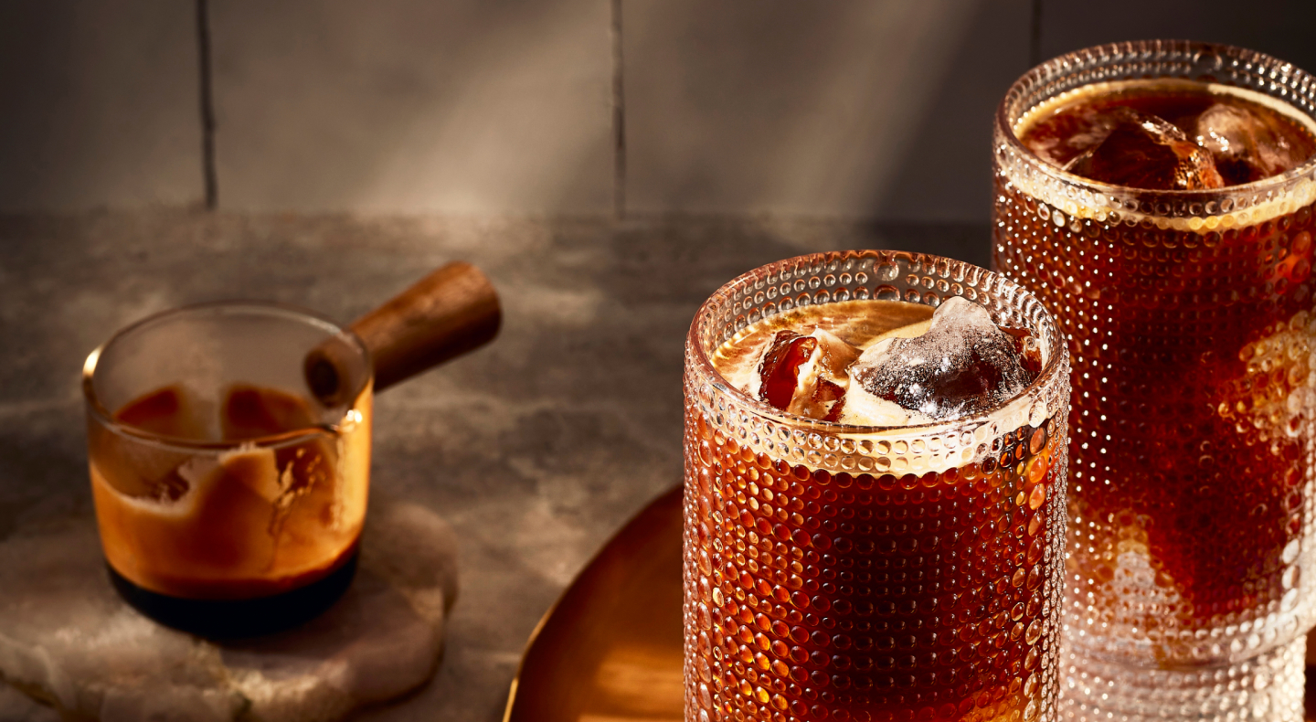 Two iced espresso drinks in tall glasses  Two iced espresso drinks in tall glasses