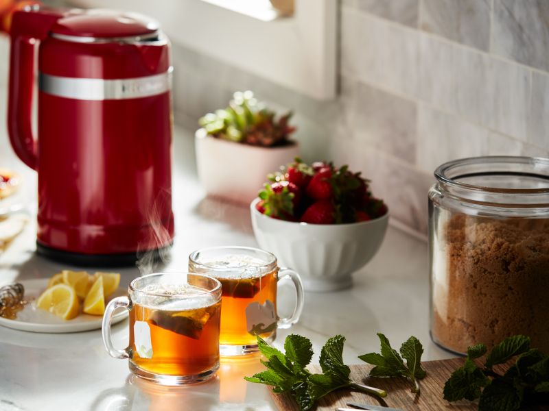 Red KitchenAid® kettle and cups of tea on a countertop Red KitchenAid® kettle and cups of tea on a countertop