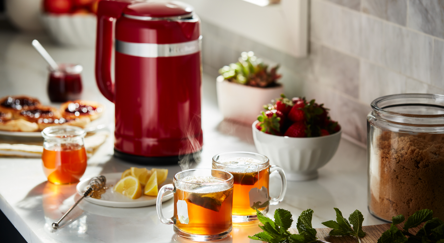 Red KitchenAid® kettle and cups of tea on a countertop Red KitchenAid® kettle and cups of tea on a countertop
