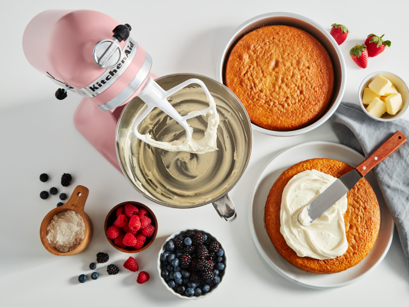 Stand mixer, cake layers and ingredients on a counter Stand mixer, cake layers and ingredients on a counter