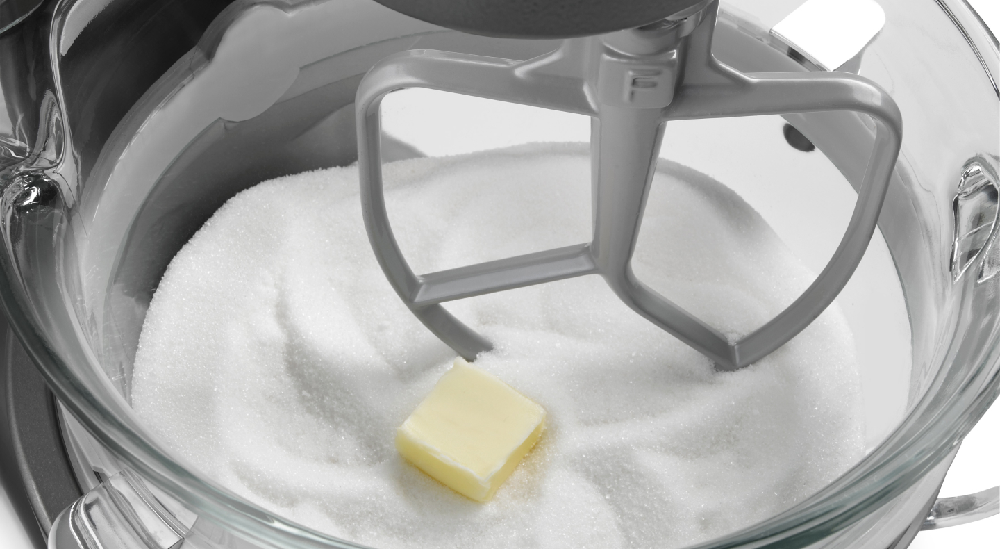 Butter and sugar in the bowl of a stand mixer with a flat beater Butter and sugar in the bowl of a stand mixer with a flat beater