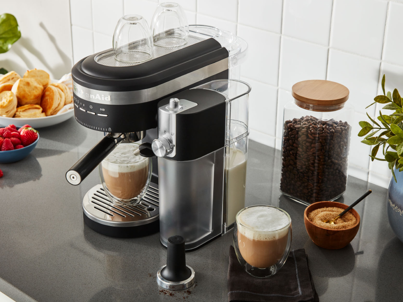 Espresso machine and milk frother on countertop with café style drinks Espresso machine and milk frother on countertop with café style drinks