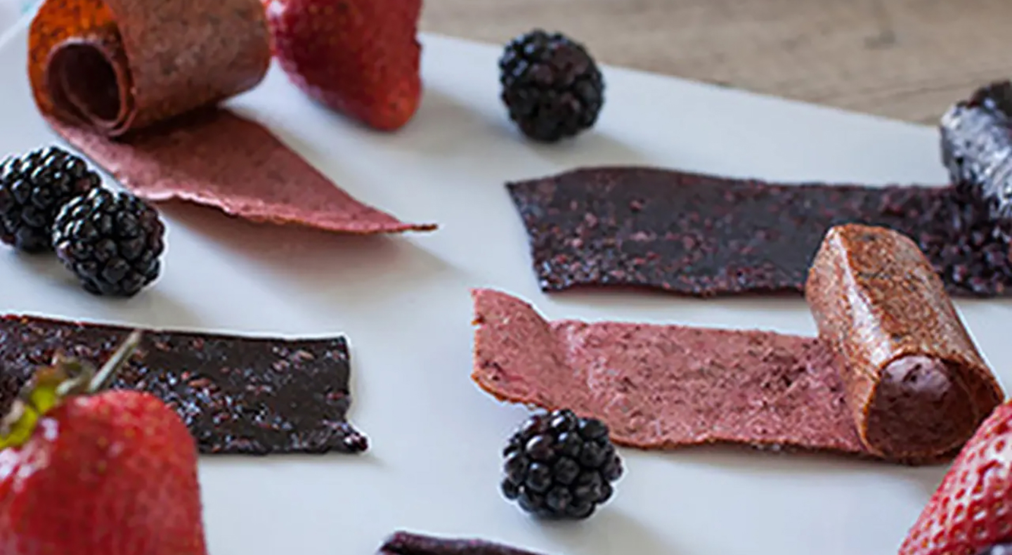 Sheets of homemade fruit leather and black berries. Sheets of homemade fruit leather and black berries.