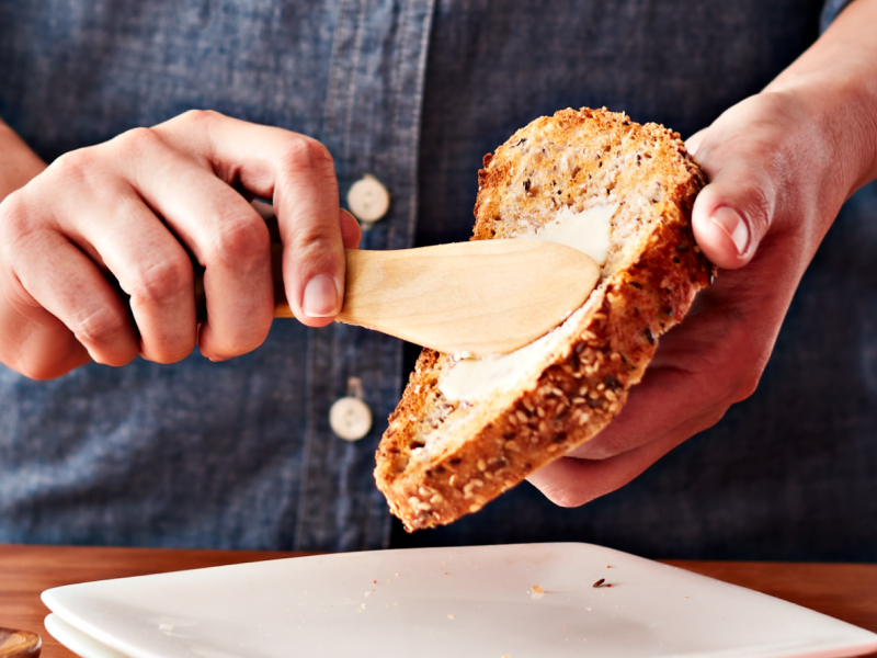 Person spreading butter on bread