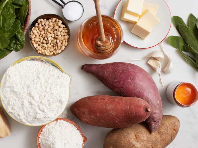 A kitchen counter with the ingredients for a sweet potato gnocchi recipe. A kitchen counter with the ingredients for a sweet potato gnocchi recipe.
