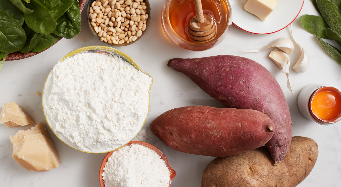 A kitchen counter with the ingredients for a sweet potato gnocchi recipe. A kitchen counter with the ingredients for a sweet potato gnocchi recipe.