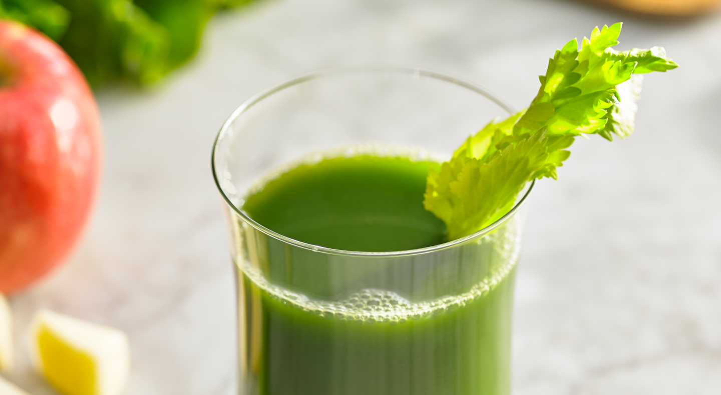 Green juice in a glass with celery Green juice in a glass with celery
