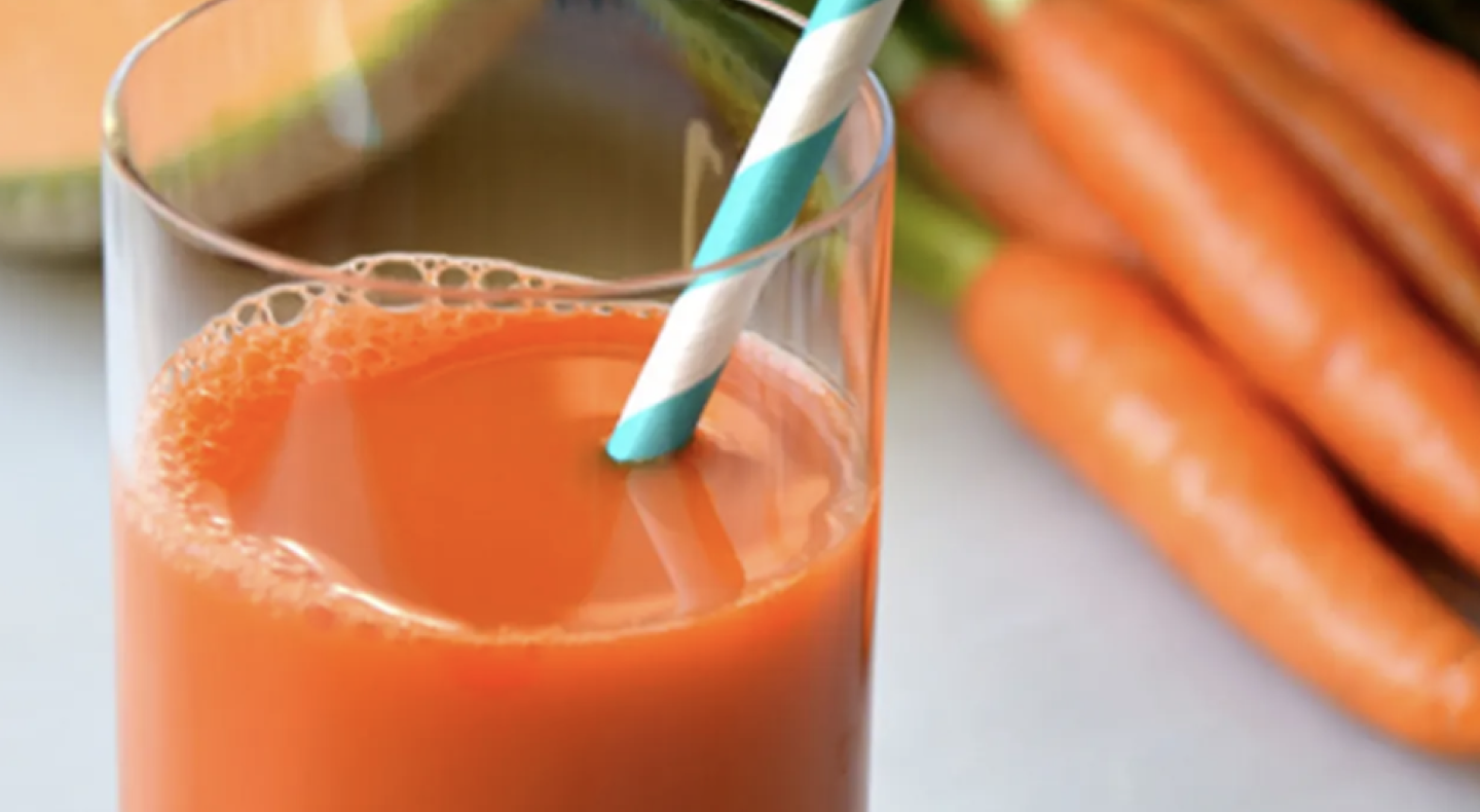 Straw in glass of carrot juice Straw in glass of carrot juice